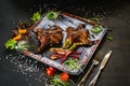 A dish with roasted quail meat with vegetables on black background Royalty Free Stock Photo