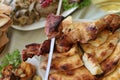 Dish with roasted young pig and bread pita. Food table background