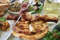 Dish with roasted young pig and vegetable salad. Food table background