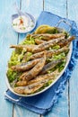 Dish of seasonal fresh fried sardines on lettuce