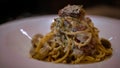 Dish of spaghetti alla carbonara on the table of a restaurant. Cuisine of Italy Royalty Free Stock Photo