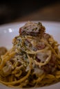 Dish of spaghetti alla carbonara on the table of a restaurant. Cuisine of Italy Royalty Free Stock Photo