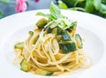 Dish of spaghetti with zucchini and mint leaves