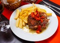 Dish of Spanish cuisine - pork cheeks with potatoes fri and stew vegetables