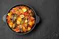 Dish with tasty ratatouille on black table, top view. Space for text