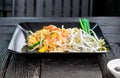 Dish of Thai styled Pan Fried Noodles, Pad Thai on a wooden back Royalty Free Stock Photo