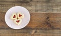 Dish with three heart-shaped cookies on a wooden base. Copy space