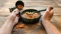 A dish of tomatoes and shrimp. Man is eating shrimp soup