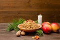 Dish of traditional Slavic treat on Christmas Eve on brown woodenplank. Pine branches, apples, walnuts, candle. Copy space Royalty Free Stock Photo