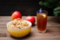 Dish of traditional Slavic treat on Christmas Eve. Christmas tree, apples, walnuts, glass of compote, candles. Brown and blak woo Royalty Free Stock Photo