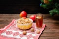 Dish of traditional Slavic treat on Christmas Eve. Christmas tree, apples, walnuts, glass of compote on a patterned tablecloth. B Royalty Free Stock Photo