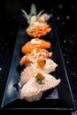 Dish of various sushi types, selective focus point with blur depth of field effect, dark atmosphere