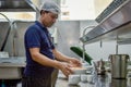 Dish washer in the uniform at the kitchen