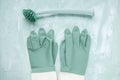 Dish washing brush and gloves on green background Royalty Free Stock Photo