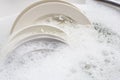 Dish washing, dishes soaking in kitchen sink Royalty Free Stock Photo