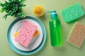 Dish washing liquid soap bottle with natural sponges and brush on green background Royalty Free Stock Photo