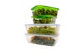 Dishes in glass containers with plastic green and whitelids front