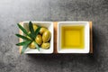 Dishes with olive oil and ripe olives on table