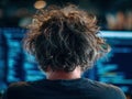 A disheveled man, focused on code at a workspace, under artificial lighting - AI-Generated Royalty Free Stock Photo