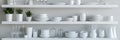 Dishware set in white shelving unit, tableware shelf, kitchen interior, clean white mugs, plates, glass tableware Royalty Free Stock Photo