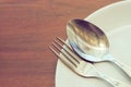 Dishware set on wood table with plate, spoon and fork Royalty Free Stock Photo