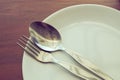 Dishware set on wood table with plate, spoon and fork Royalty Free Stock Photo