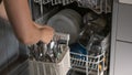 Dishwasher disassembly.Womens hands sort clean dishes from the dishwasher. Plates, forks and glasses in the dishwasher Royalty Free Stock Photo