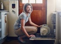 The dishwasher is every homemakers best friend. Portrait of a young woman using a dishwashing machine at home. Royalty Free Stock Photo