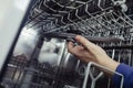 Dishwasher repair. A service center representative diagnoses and repairs a dishwashing machine at home. Specialist in working with Royalty Free Stock Photo