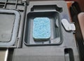 Dishwasher tab in tablet bin closeup. Hygiene and house cleaning