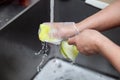 Dishwasher in uniform washes griddle with foam and sponge under the tap water Royalty Free Stock Photo