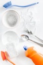 Dishwashing liquid, sponge, brush and tableware on white background top view Royalty Free Stock Photo