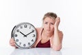 Disillusioned beautiful young blond woman holding a clock