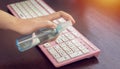 Disinfect, sanitize, hygiene care. people using alcohol spray on computer keyboard and frequently touched area for cleaning