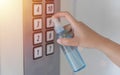 Disinfect, sanitize, hygiene care. people using alcohol spray on elevator button and frequently touched area for cleaning