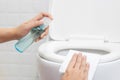 Disinfect, sanitize, hygiene care. people using alcohol spray on toilet seat lid and frequently touched area for cleaning