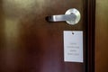 Disinfected hotel room is ready for new guests and tourists. A sign hanging on the handle saying the room has been