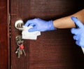 Disinfecting surfaces from bacteria or viruses, hand cleaning door handle with disinfectant against coronavirus covid-19. Hand in Royalty Free Stock Photo