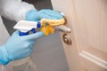 Disinfection and cleaning door handles of house from infection with virus and microbes in biochemical suit. Coronavirus