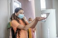 Girl in preventive mask getting some sanitizer into her hand