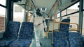 Disinfectors use sprayers to sanitize a bus from the inside.