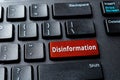 Disinformation red key on the black desktop keyboard. Warning message on the computer enter key. Propaganda, manipulation and Royalty Free Stock Photo