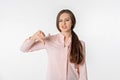 Dislike. Disgusted young woman shows thumb down, grimaces and complains, disappointed by promo, upsetting news, standing against Royalty Free Stock Photo