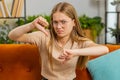 Upset young woman showing thumbs down, dislike bad work, disapproval, dissatisfied feedback at home Royalty Free Stock Photo