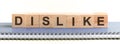 DISLIKE - a word made of wooden blocks with black letters, a row of blocks is located on a grey notepad Royalty Free Stock Photo