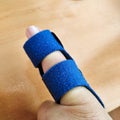 Dislocated little finger joint treatment with a blue protective splint Royalty Free Stock Photo