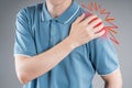 Dislocation of the shoulder, joint inflammation, arthritis and degenerative changes, man with pain in his arm on gray background Royalty Free Stock Photo
