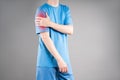 Dislocation of the shoulder, joint inflammation, arthritis and degenerative changes, man with pain in his arm on gray background Royalty Free Stock Photo