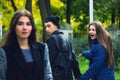 Disloyal man walking with girlfriend and looking amazed at another seductive girl Royalty Free Stock Photo