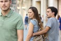 Disloyal woman looking another man and her angry boyfriend Royalty Free Stock Photo